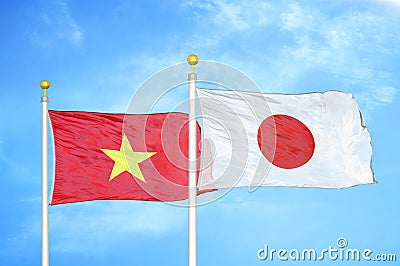 Vietnam and Japan two flags on flagpoles and blue sky Stock Photo