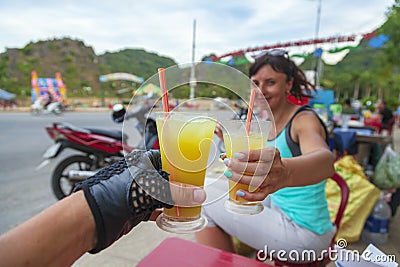 Vietnam. A motorcycle trip, a young couple drinks chilled juice. Cane-juice from sugar cane for tourists Stock Photo