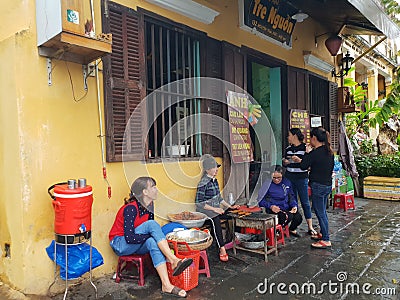 Vietnamese ladies chat in front of local food shop in Hoi an ancient street town in Vietnam. Editorial Stock Photo