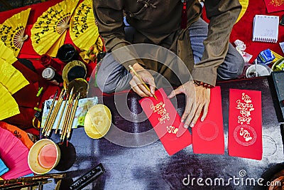 Vietnamese scholar writes calligraphy at lunar new year. Calligraphy festival is a popular tradition during Tet holiday Editorial Stock Photo