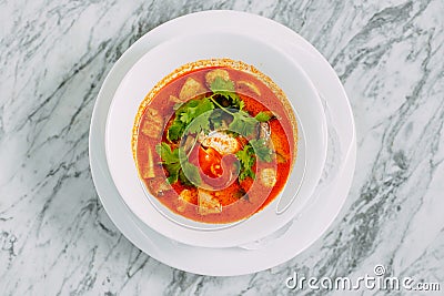 Vietnamese spicy tom yam soup on a marble table Stock Photo