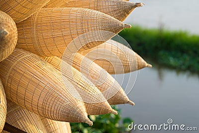 Vietnamese traditional bamboo fish traps against cultivation field on background Stock Photo