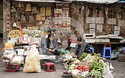 Vietnamese vendors sell vegetables, fruits and sundries on the streets of Hanoi. Vietnam Editorial Stock Photo