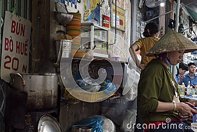 Vietnamese woman prepares food at a street soup shop in Ho Chi Minh City, Vietnam Editorial Stock Photo