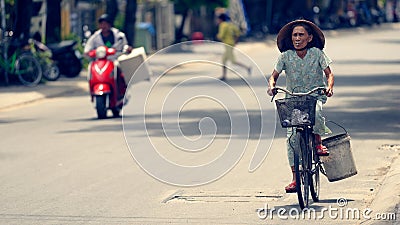 Vietnamese woman riding bicycle in Hoi An Editorial Stock Photo