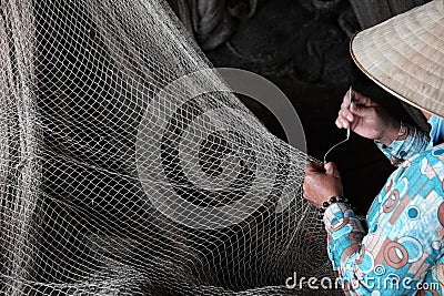 Vietnamese woman sewing fishing net Editorial Stock Photo