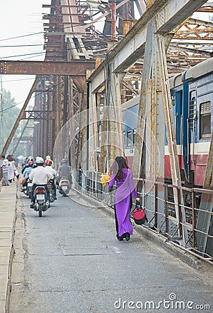 Vietnamese woman in traditional dress Ao Dai walking on old Long Bien bridge, Hanoi city Editorial Stock Photo