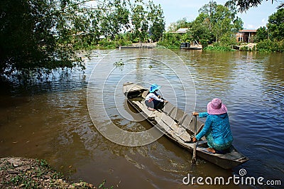 Vietnamese woman transport little girl go to school by wooden boat Editorial Stock Photo