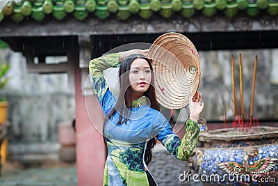 Vietnamese women wear Ao dai in the rain Stock Photo