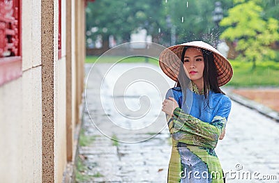Vietnamese women wear Ao dai in the rain Stock Photo