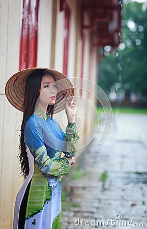 Vietnamese women wear Ao dai in the rain Stock Photo