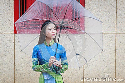 Vietnamese women wear Ao dai in the rain Stock Photo