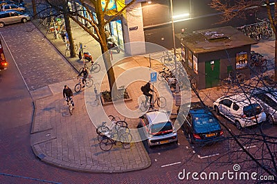 View above Amsterdam street with bicycle and cars parking illuminated in the evening, Netherlands Editorial Stock Photo