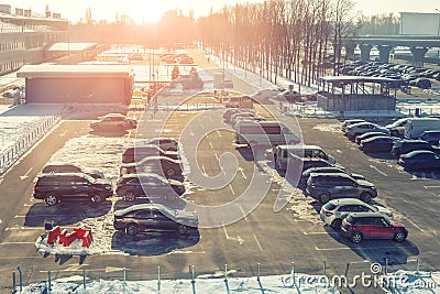 View from above on car parking with many vehicles and free lots at bright early frosty cold winter morning. Parking lot with Stock Photo