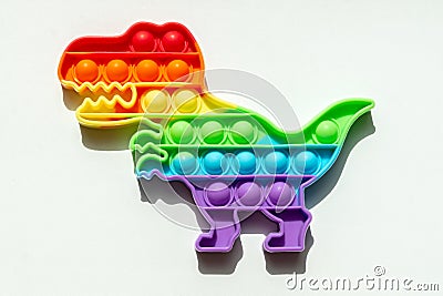 View from above on rainbow color popit in the shape of a dinosaur Stock Photo