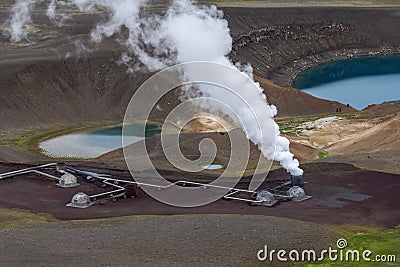 View at active steam stack and parts of Krafla geothermal power plant next by the volcano crater with Krafla Viti lake in Northern Stock Photo
