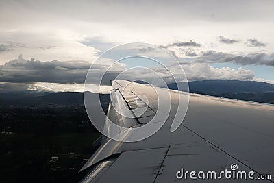 View from the airplane window with the sky and white clouds at the sunset. Flight above Ecuador Quito. Stock Photo