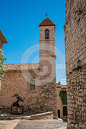 View alley and church with stone steeple tower in Saint-Paul-de-Vence. Stock Photo