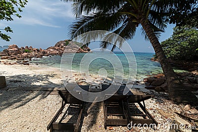 Two chair waiting for tourists at a corol reef rock landscape with a pure blue sky and a green clear water Stock Photo