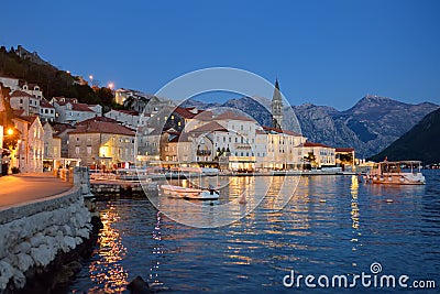 View of ancient picturesque city of Perast, Montenegro. Old medieval little town with red roofs and mountains on background of Stock Photo