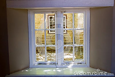 View through an antique window into the dappled sunshine on an inner courtyard at a farmhouse in the KaroO South Africa Stock Photo