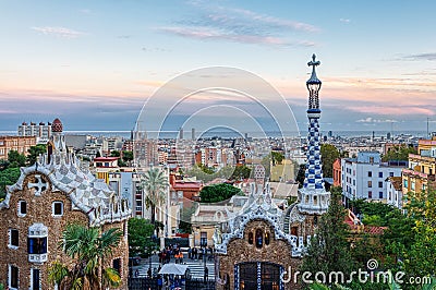 View of Barcelona from Park Guell at the sunset. In the foreground the colourful buildings of the main entrance. Barcelona Editorial Stock Photo