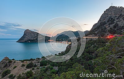 View of the Bay to the resort village near the mountains and with a large headland in the sea at sunset. Cape Chyken Peninsula of Stock Photo