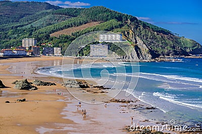 View of the beach of Bakio town. People walk on the sand at low tide. Near Bilbao and Gaztelugatxe, Basque Country, Northern Spain Editorial Stock Photo