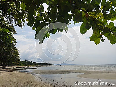 View of the beach with low tide and a stranded fishing boat. Stock Photo