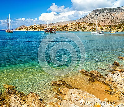 View of beautiful bay in panormitis Symi island , ships. and boats at anchor, Greece Editorial Stock Photo