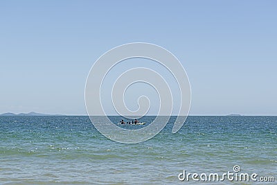 View of beautiful beach in FlorianÃ³polis, Brazil. Two men kayaking in the turquoise sea under beautiful clear sky on vacation day Stock Photo