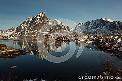 View of beautiful Sacrisoya village in winter time with montains in background with light of sunrise. Lofoten, Norway Stock Photo