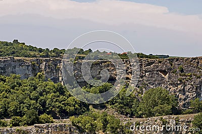 View of the beautiful village of Nisovo, Bulgaria, located below, above and in the high limestone cliffs Stock Photo