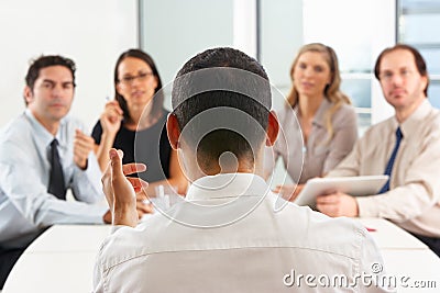 View From Behind As CEO Addresses Meeting Stock Photo