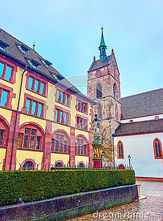 The view on bell tower of Martinskirche with colorful Sevogelbrunnen fountain on the foreground, Basel, Switzerland Stock Photo