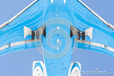 View from below under the flying airplane before landing, in detail chassis, wings, flaps, fuselage and engine Stock Photo