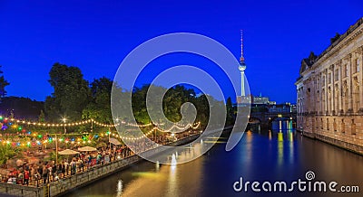 View on Berlin television tower and open air beer garden at shore of river Spree during evening twillight in summer Editorial Stock Photo