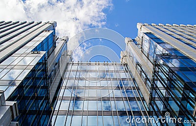 A view from the bottom up to a modern tall office building with countless rows of identical windows Stock Photo