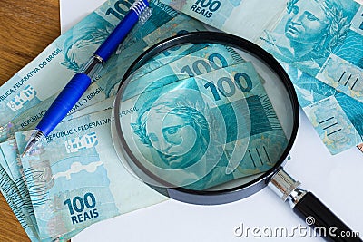 View of the Brazilian money, reais, high nominal with a sheet of paper and a pen for calculations Stock Photo