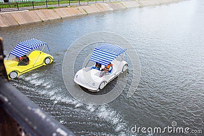 View from the bridge on the riding people in catamarans. Alloy by the boat down the river. City entertainments Stock Photo