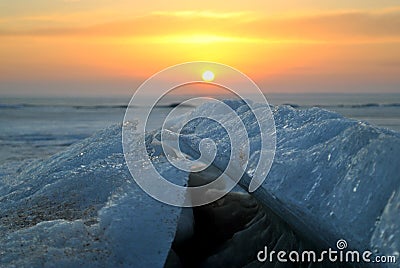View of the broken melting ice cover of the Volga River against the backdrop of a magnificent sunset and clouds. Stock Photo