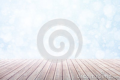 View on a brown wooden table against a winter snowfall with bokeh Stock Photo