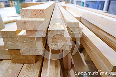 View from butt of stack of three-layer wooden glued laminated timber beams from pine finger joint spliced boards Stock Photo