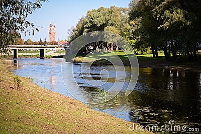 View of the calm current and the banks of the Polist River, Bridge and the old water tower in the ancient city of Staraya Russa. Stock Photo