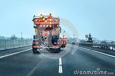 View from the car behind orange highway maintenance truck Stock Photo