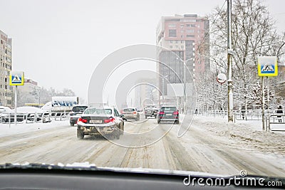 View from the car window during rain and wet snow. Poor visibility while driving around the city. Snowy road Stock Photo