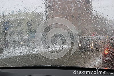 View from the car windscreen during rain and wet snow. Poor visibility while driving around the city. Snowy road Stock Photo