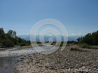 View of the Carpathian Mountains over a small rocky river Stock Photo