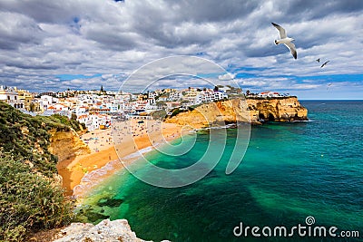 View of Carvoeiro fishing village with beautiful beach, Algarve, Portugal. View of beach in Carvoeiro town with colorful houses on Stock Photo