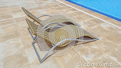 View of chair loungers in resort hotel with pool of transparent and crystal clear water Stock Photo